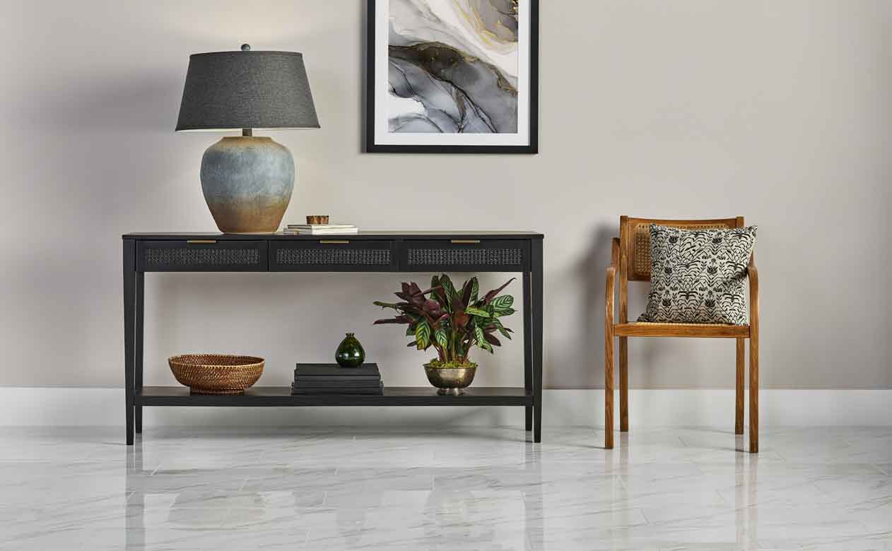 contemporary entryway with sleek marble tile, black entryway table and rattan chair